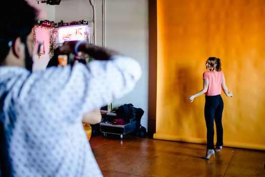 Woman posing during a vibrant fashion photoshoot in a professional studio.