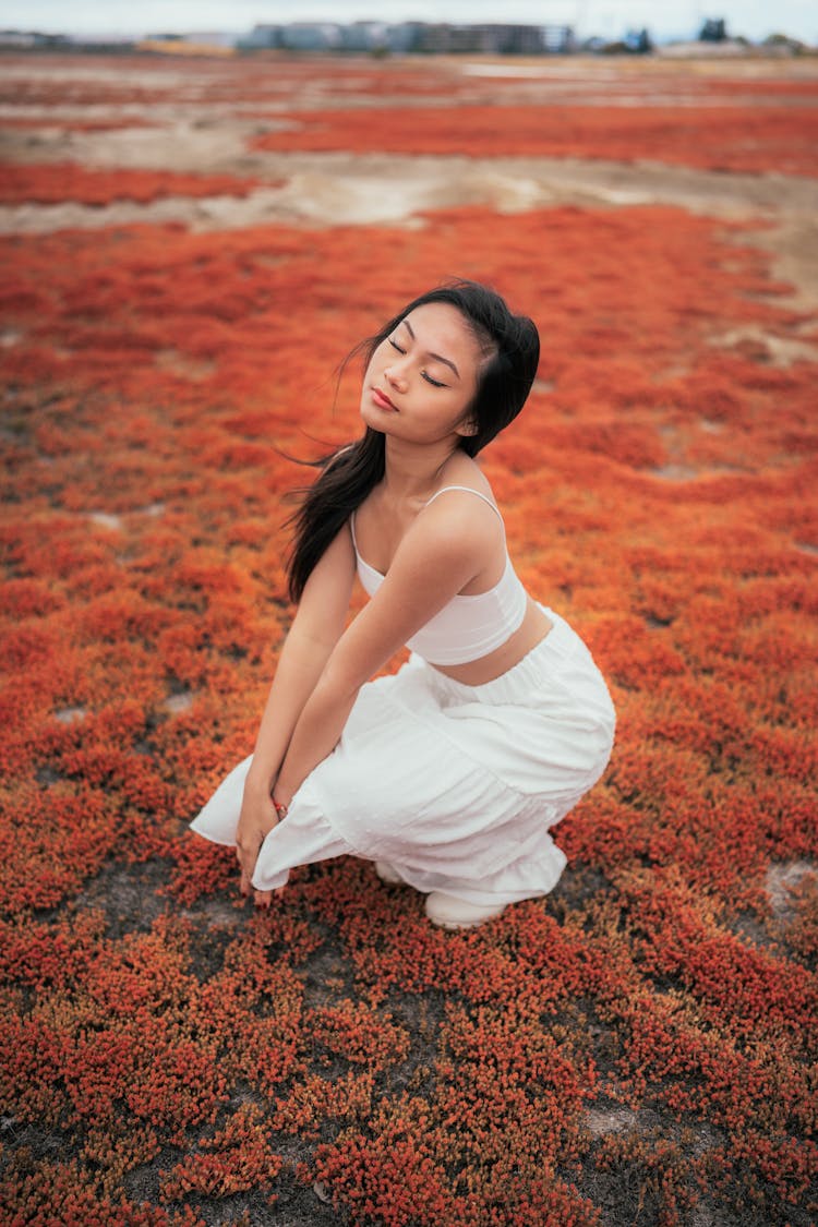 Woman Crouching On A Field 