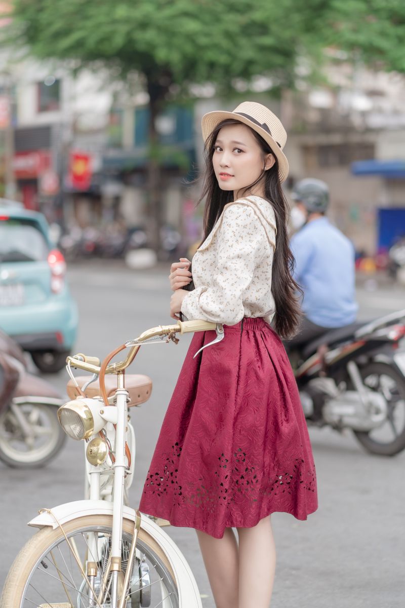 woman in cream lace blouse and burgundy midi skirt