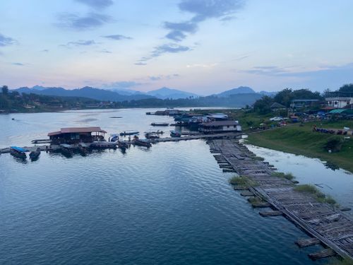 Free Picturesque view of a serene riverside town at dusk featuring floating houses and calm waters. Stock Photo