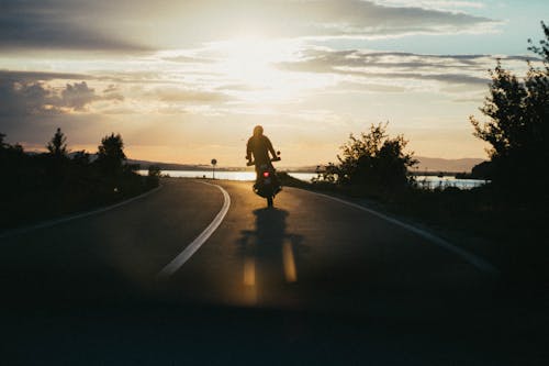 Person, Die Motorrad Während Der Goldenen Stunde Reitet