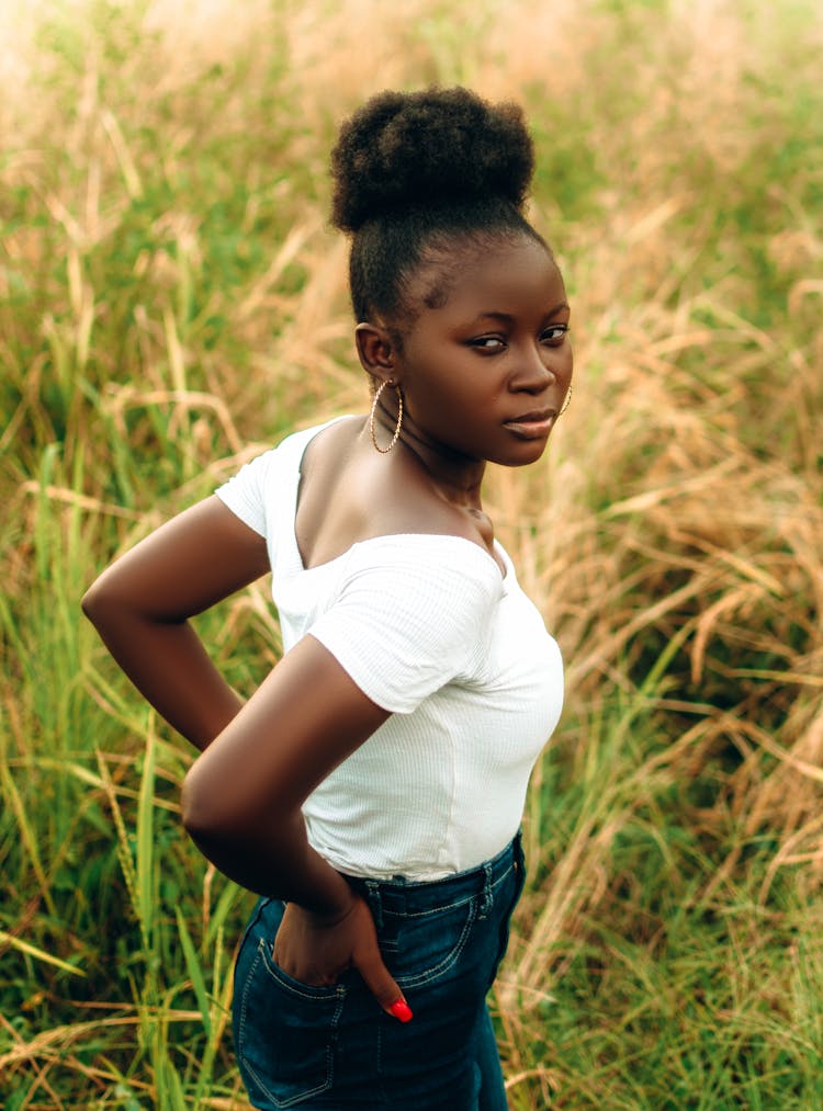 Fashion Woman In Jeans And White Shirt Posing In Field