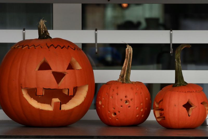 Close-up of a hand-carved pumpkin face with detailed features