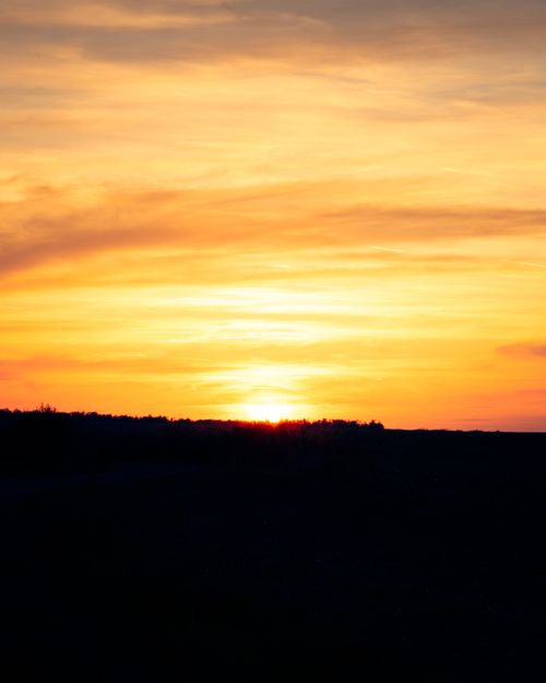 Free Captivating sunset with vivid orange hues over serene hills, perfect for nature lovers. Stock Photo