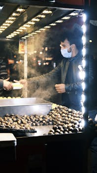 Street vendor serving roasted chestnuts at a night market in Istanbul, Turkey.