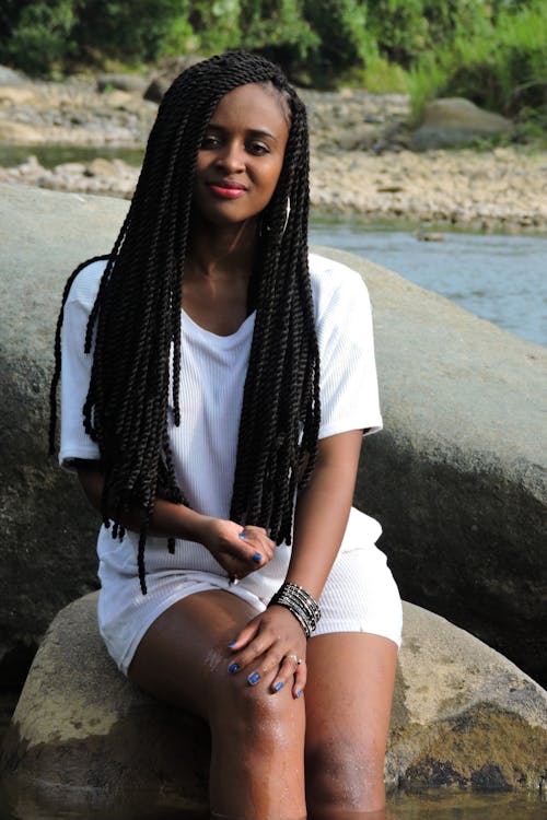 Woman in White Crew-neck Dress Sitting on Rock