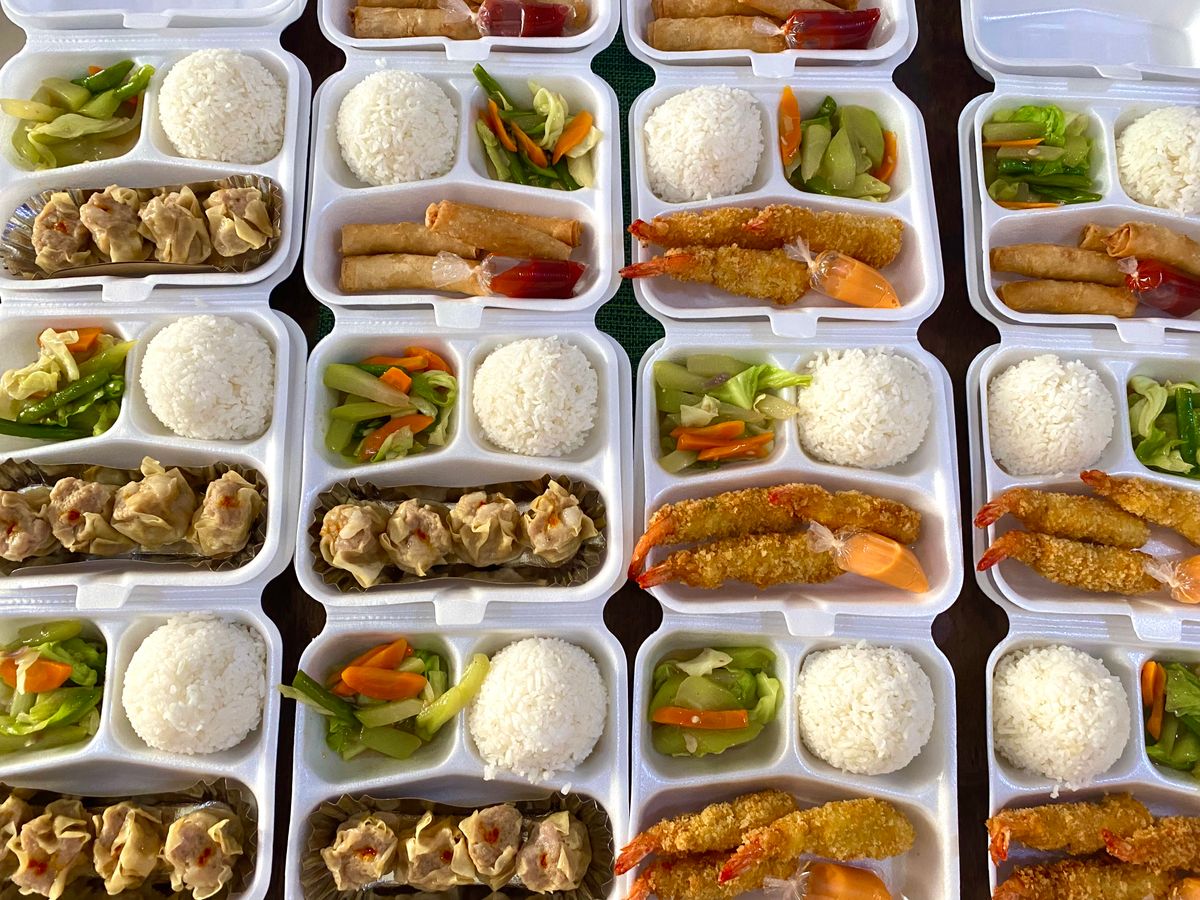 Four adult meal-prep bento boxes lined up with rice, protein, and vegetables