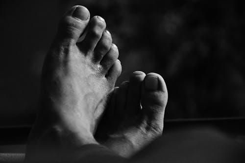 Grayscale Photo of a Person's Feet