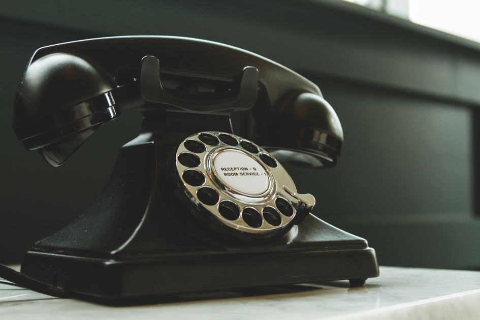 Classic black rotary phone on hotel reception desk, evoking nostalgia and vintage charm. Related image for AI in hospitality in USA hotels.