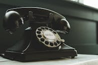 Black Rotary Telephone on White Surface