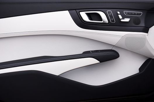 Close-up of a modern car door panel with a minimalist design and luxury materials.