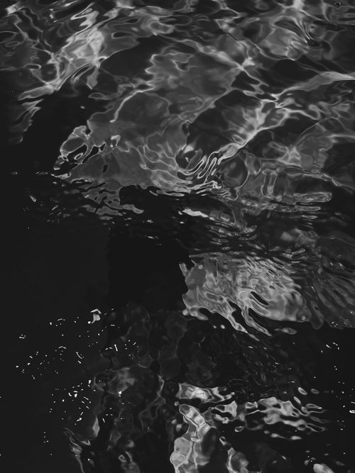 Free Black and white abstract image showcasing light reflections on water surface. Stock Photo