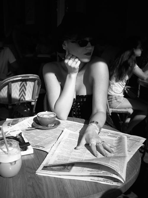 Free Woman Posing with Newspapers on Table Stock Photo