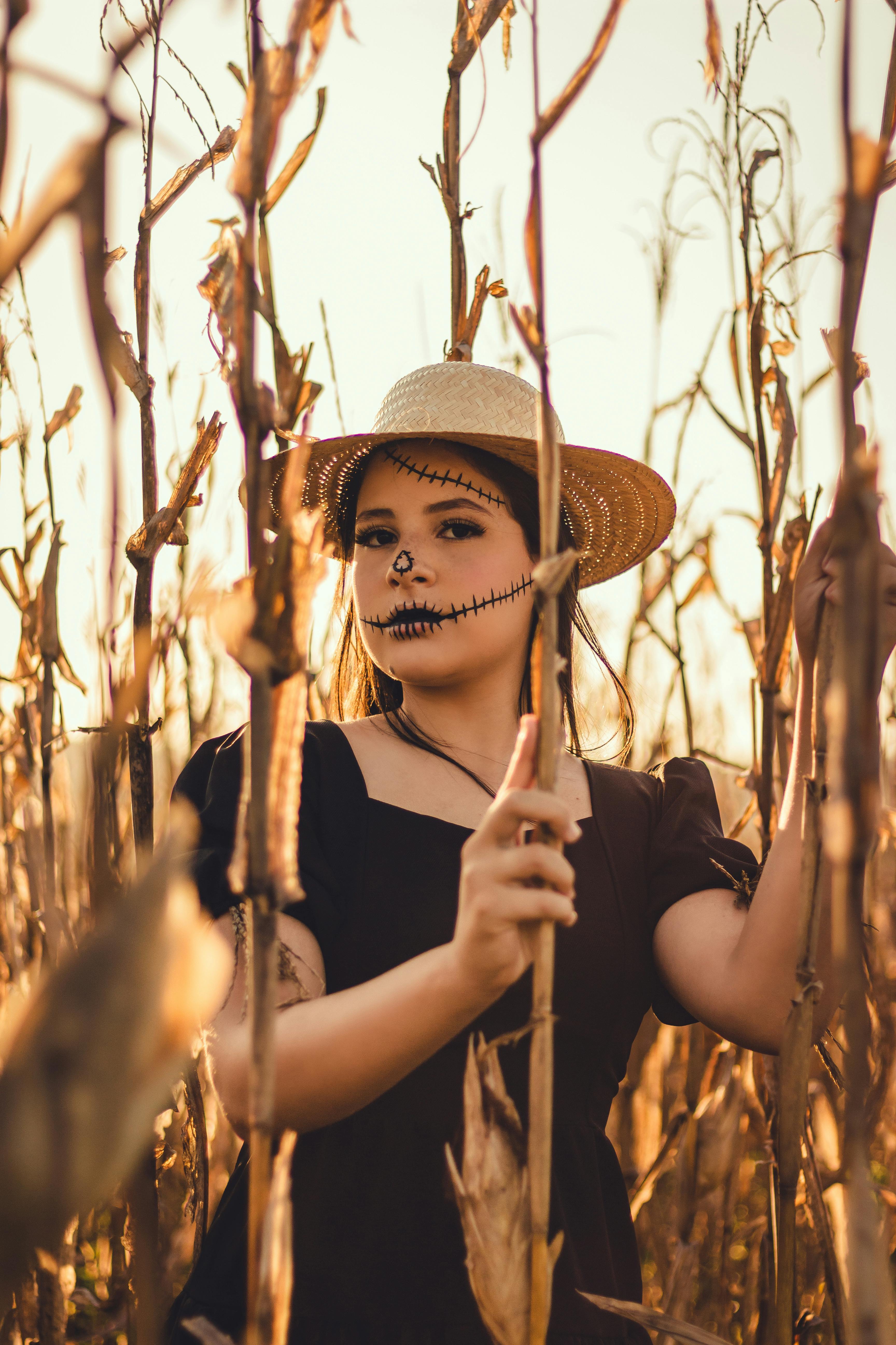 girl with halloween makeup standing in corn field