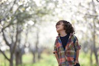 一个穿着彩色格子衬衫的快乐孩子正在户外享受春日