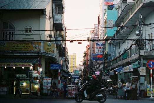 Colorful busy street scene in Cần Thơ, Vietnam with vibrant signs and people.