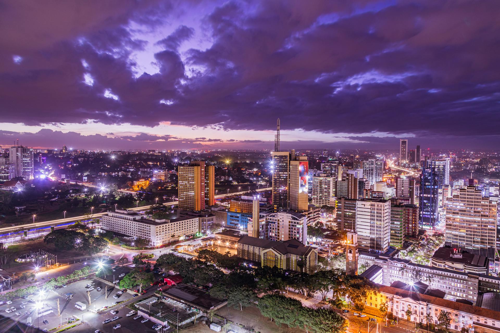 Illuminated Cityscape and Purple Sky with Clouds