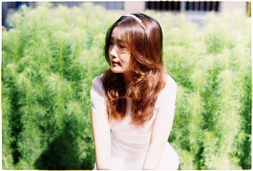 Free Young woman with brown hair in a sunlit garden in Cần Thơ, Vietnam. Stock Photo