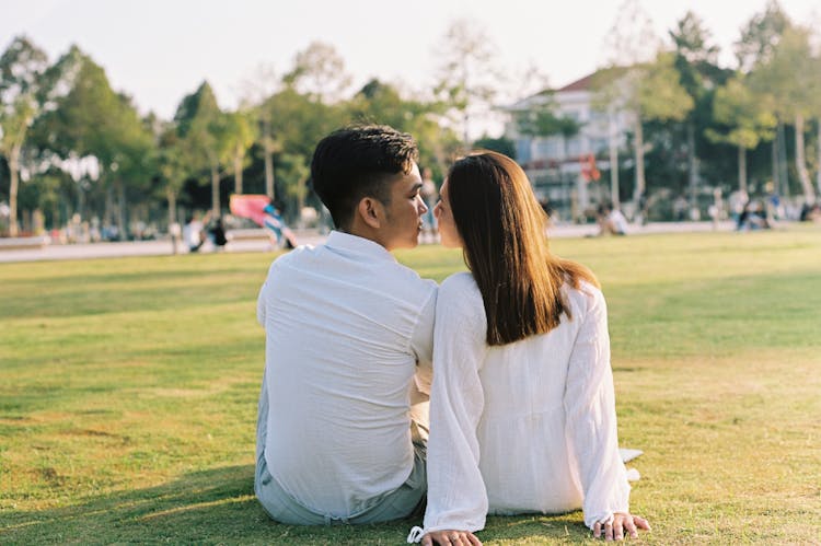 Lovely Couple Kissing On Green Grass Field