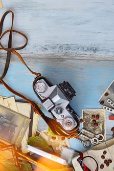 Flat lay of a vintage camera with scattered coffee beans and old photos on a rustic wooden table.