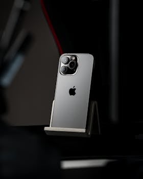 A modern smartphone displayed on a stand against a dark, minimalist background.
