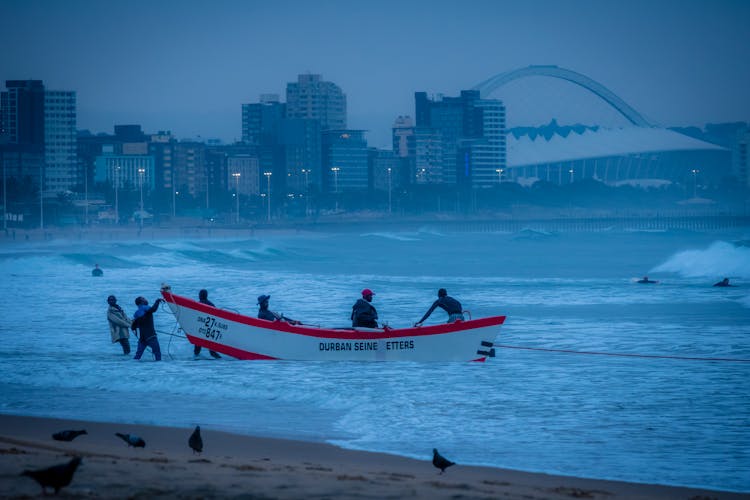 Men Pulling A Boat To The Shore During A Storm 