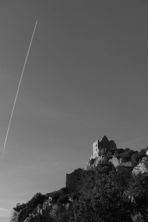 Grayscale Photo of Castle on Top of the Mountain