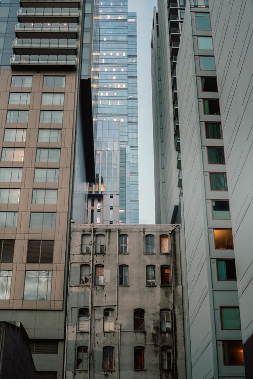 Free Contrasting view of modern skyscrapers alongside an old building, depicting urban evolution. Stock Photo
