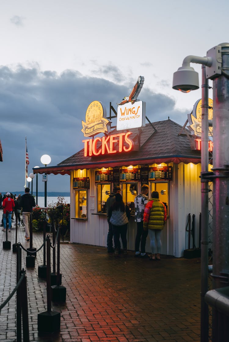 People Standing In Front Of A Ticket Booth 