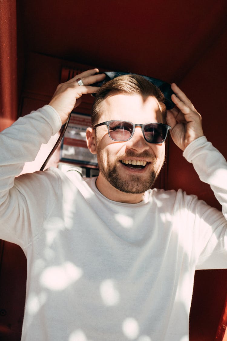 Smiling Man In Sunglasses Posing In Phone Booth