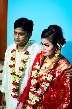 Elegant portrait of an Asian couple in traditional wedding attire.