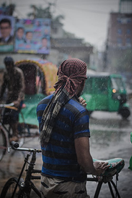 Man Wearing Headscarf with a Bike on a Street