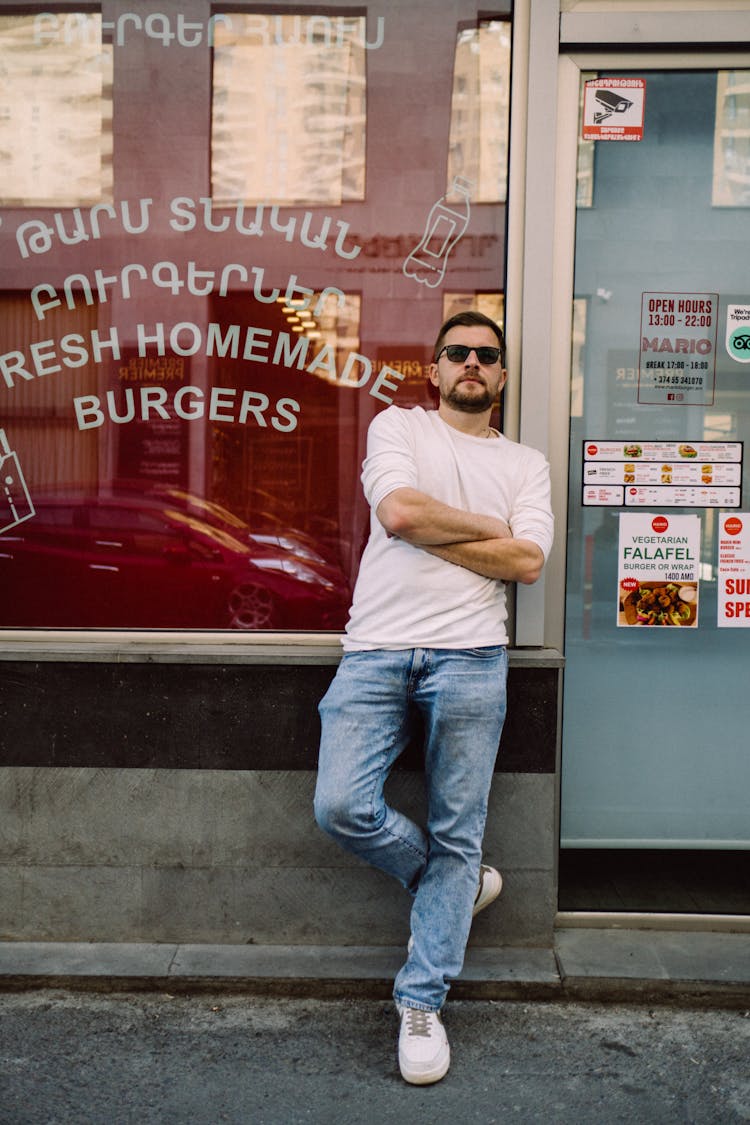 Man In Sunglasses Posing Near Shop Showcase