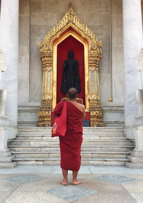 Man Praying in front of a Shrine of the Buddha