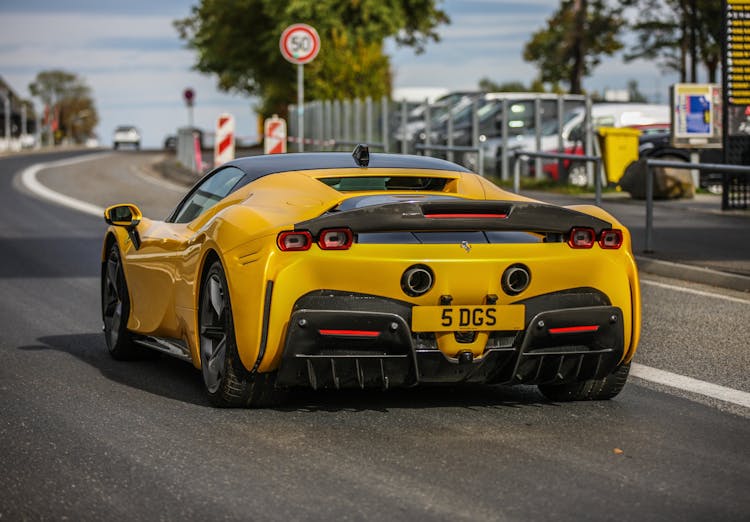 Back View Shot Of Yellow Ferrari Car Moving On The Road