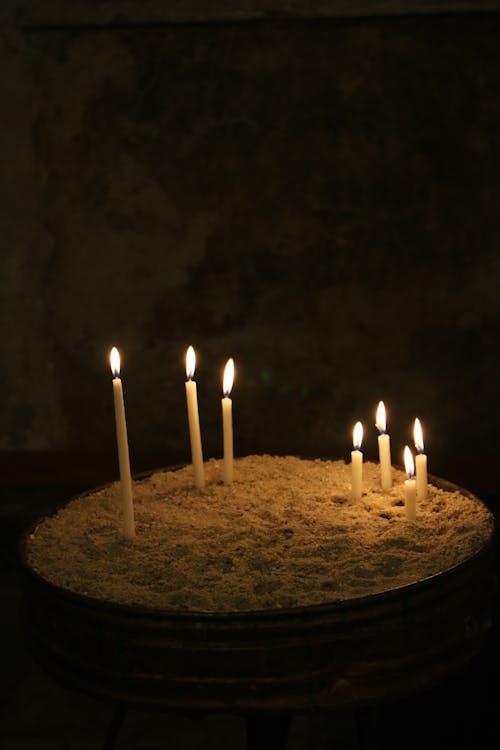 Lighted Candles on Bucket of Sand