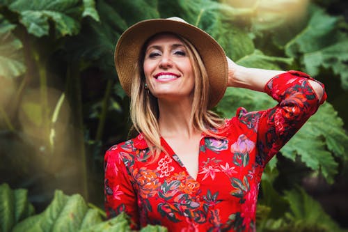 Vrouw Houdt Haar Achterhoofd Met Bruine Hoed En Rode En Veelkleurige Bloemenknoopblouse Met Lange Mouwen