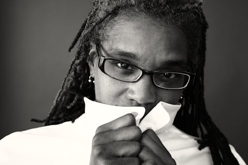 Grayscale Photography of Woman Covering Mouth by White Top