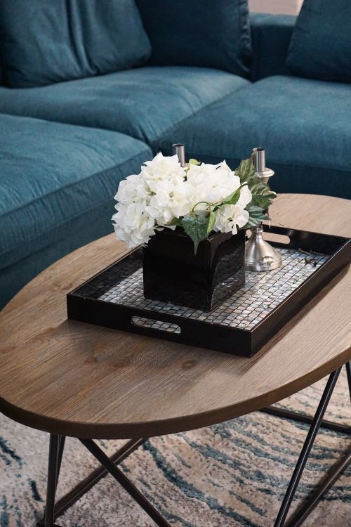 Free A cozy living room featuring a wooden table with elegant floral decor in a modern setting. Stock Photo