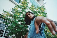 一名南亚女子身着牛仔夹克，以绿色为背景，表情丰富