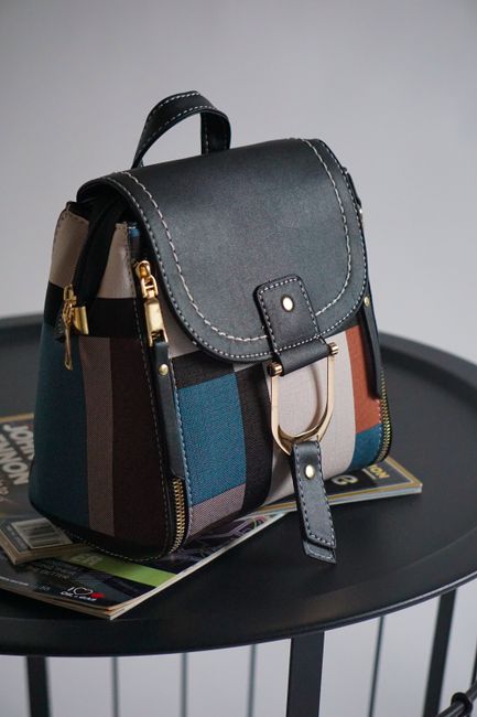 Elegant multicolor patchwork handbag with a gold accent on a black round table, perfect for fashion shoots. - choose handbag for different occasions Pakistan