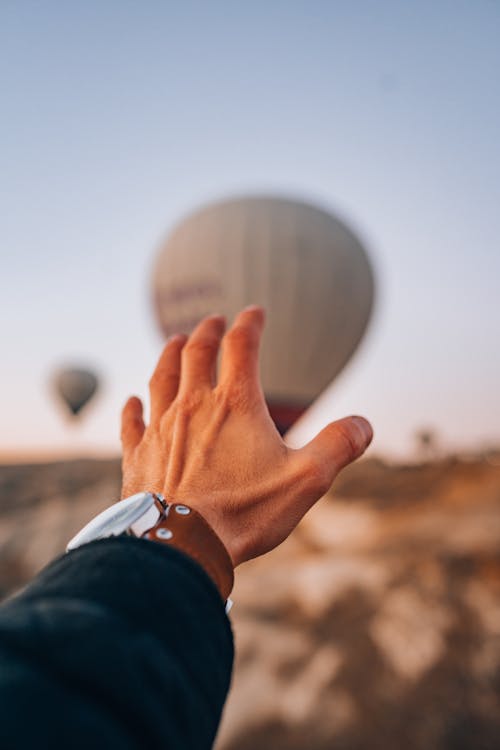 Hand Reaching Towards Hot Air Balloons