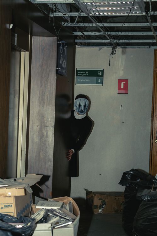 Free Explore the eerie atmosphere of an abandoned building with a mysterious masked figure in a dimly lit hallway. Stock Photo