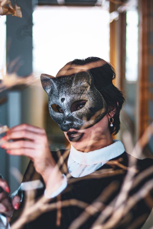 A Person in White and Black Top Wearing Fox Mask During Halloween