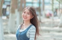 Woman Smiling and Wearing White and Gray Striped Shirt