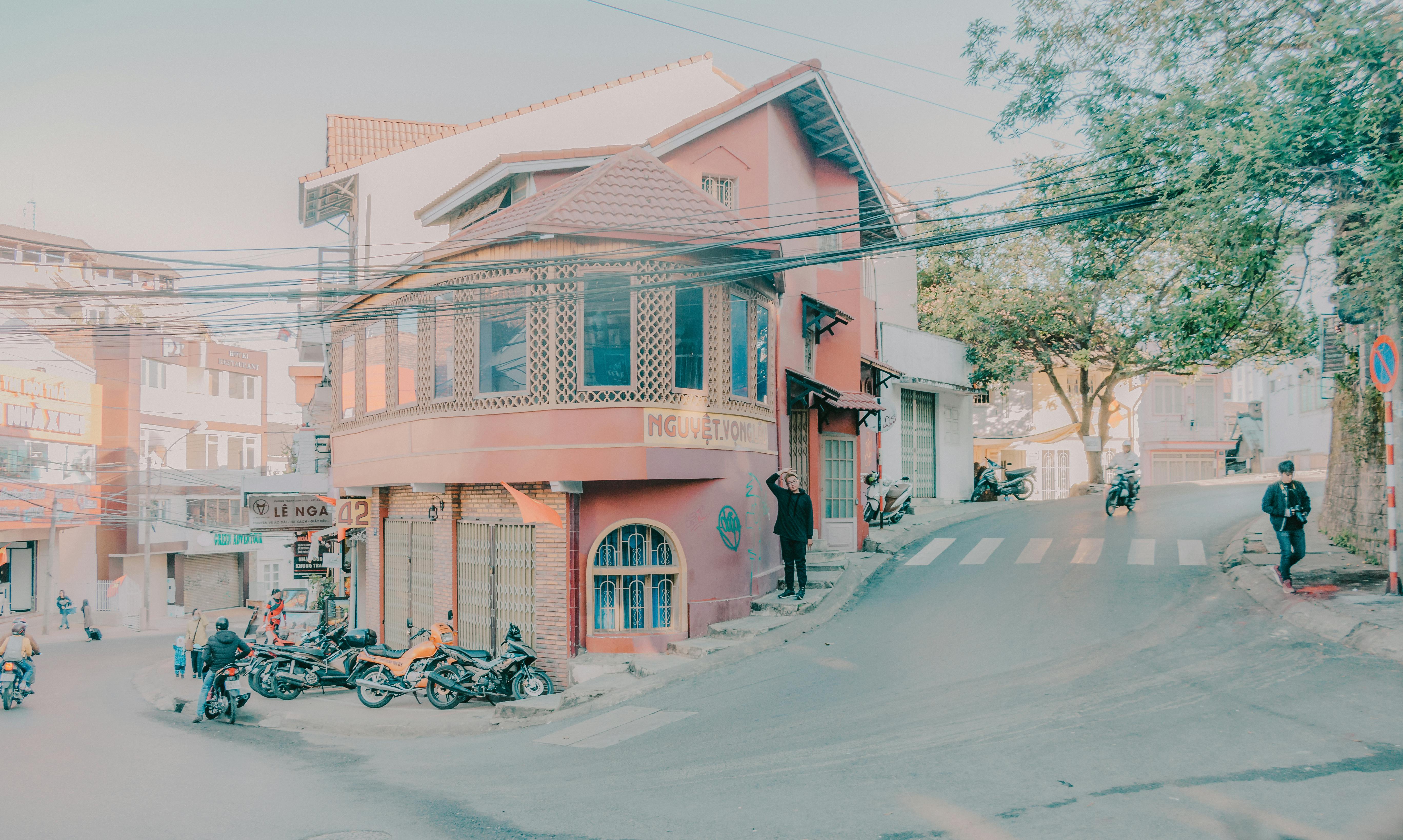 Free Charming urban corner street view featuring classic architecture and parked motorcycles. Stock Photo