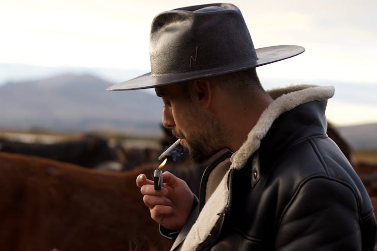 Man In Hat Lighting Cigarette