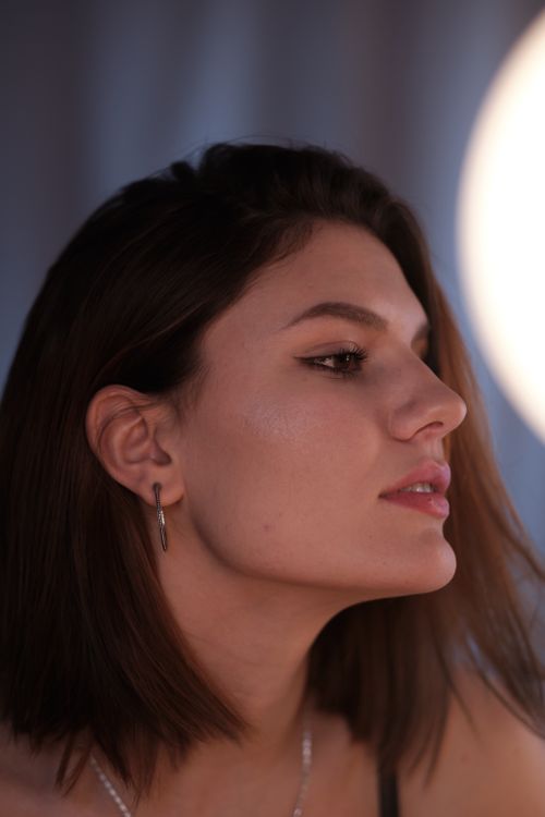Free Elegant side profile of a young woman with soft lighting and a serene expression. Stock Photo