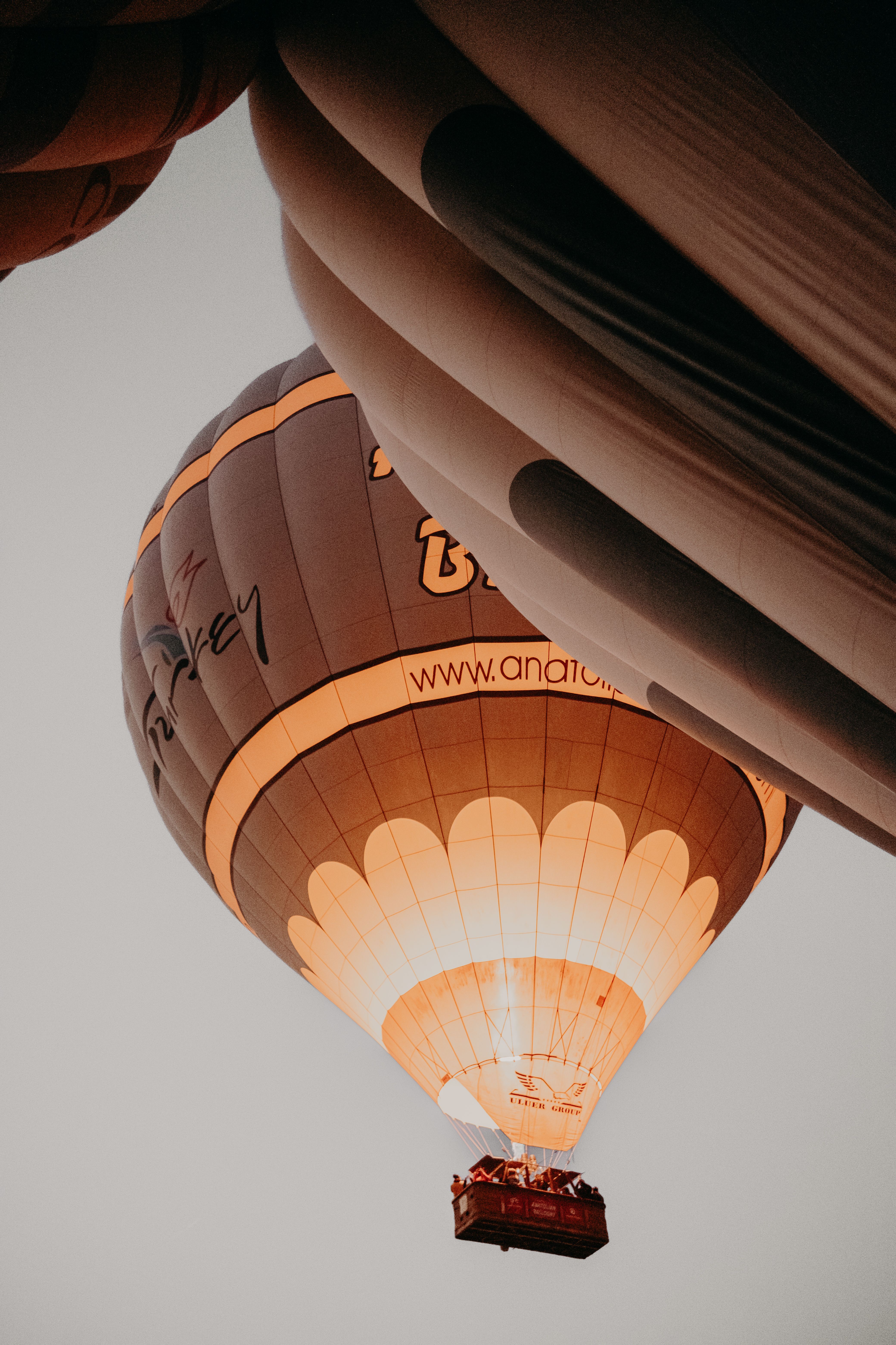 Dramatic low angle shot of an illuminated hot air balloon flying over Cappadocia, Turkey.