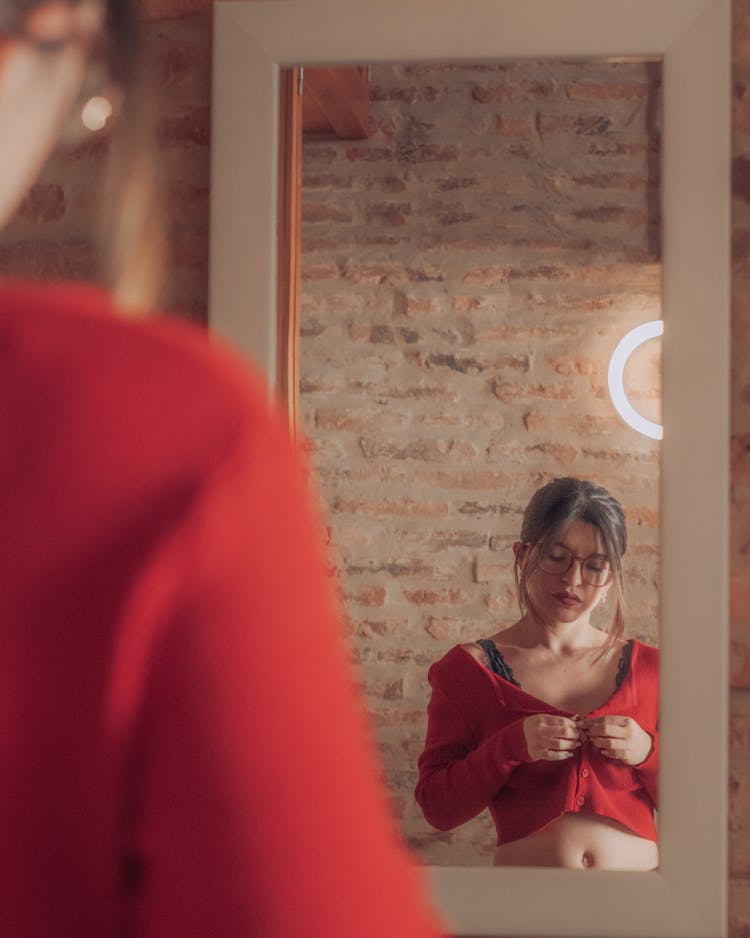 Mirror Reflection Of Woman Fixing Her Clothes 